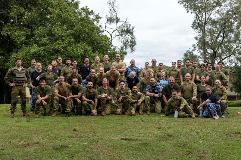 A large group of military personnel gather outside.