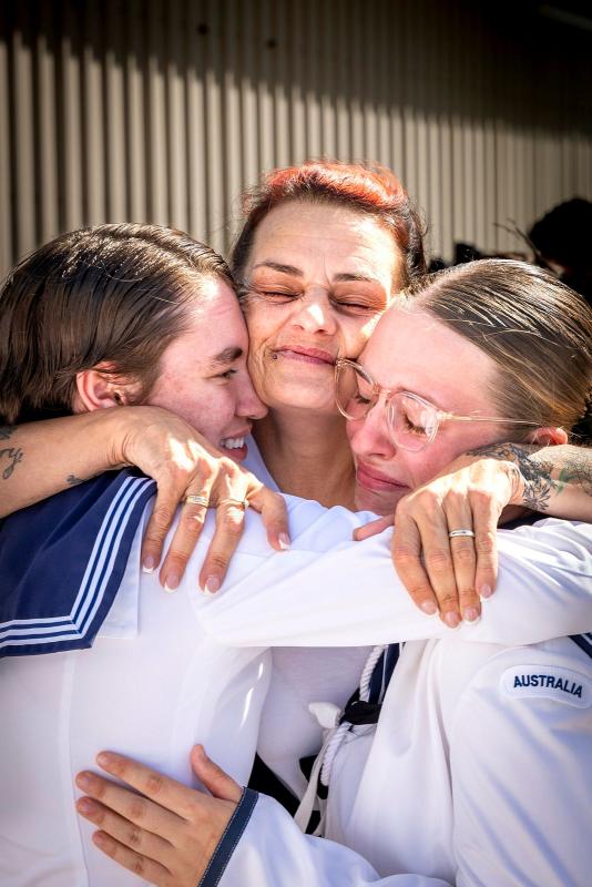 Three woman cry and hug each other.