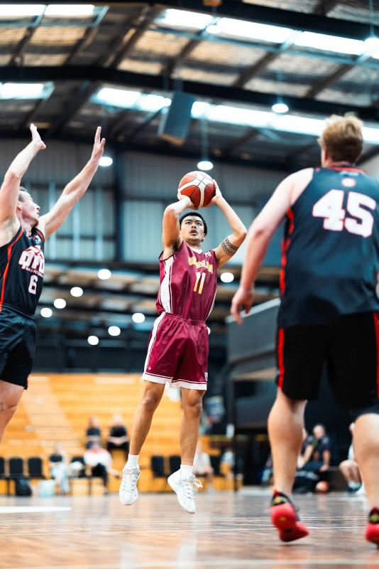 A basketballer jumps to shoot a shot during a game.