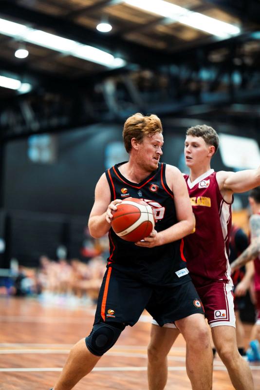 Two men compete in a game of basketball.