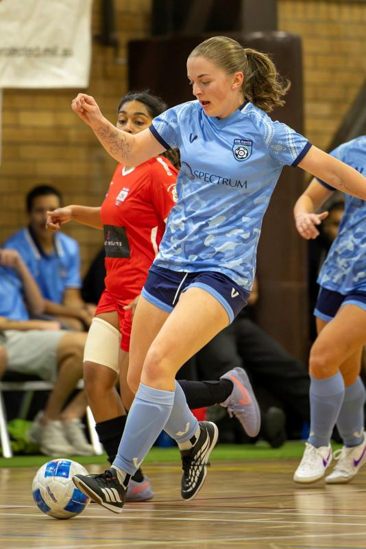 A female player competes in a game of futsal.