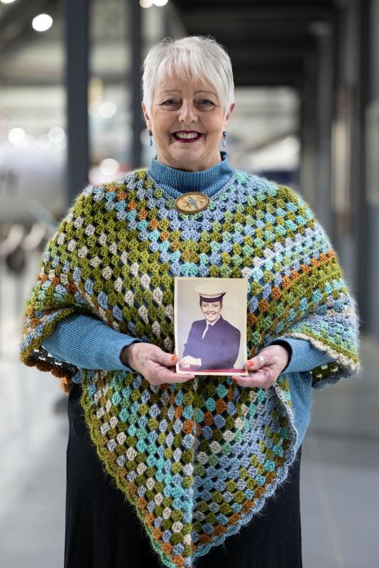 Former RAN member Sandi Foley holds her official portrait at the opening of the Women in Navy exhibition.