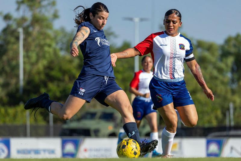 Two women play football.