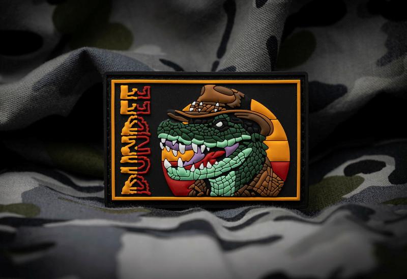A badge of a crocodile wearing a hat.