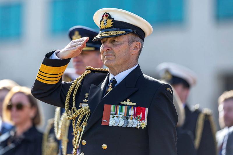 A man stands and salutes.