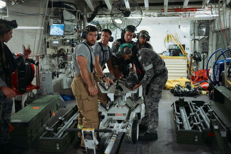 Five people surround a missile.