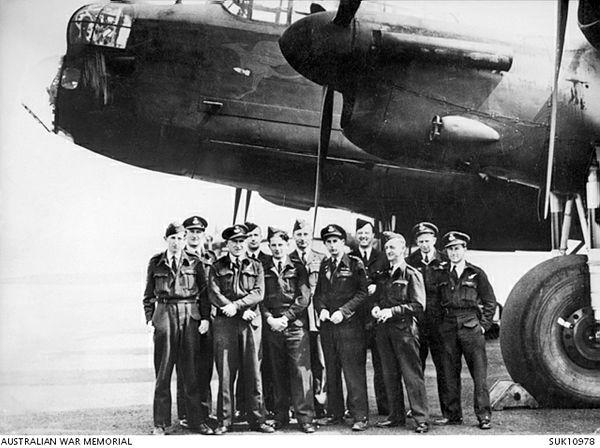 A black-and-white photo of a group of military men in front of an aircraft.