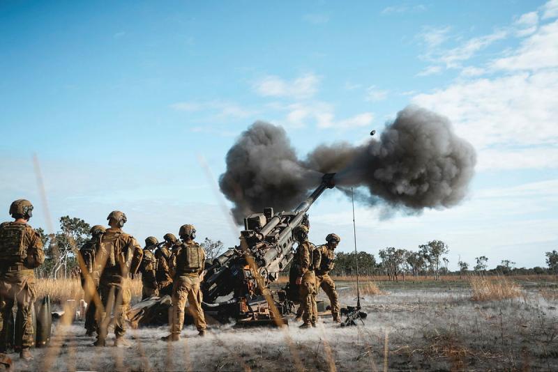 Soldiers fire a cannon-like weapon into the sky.