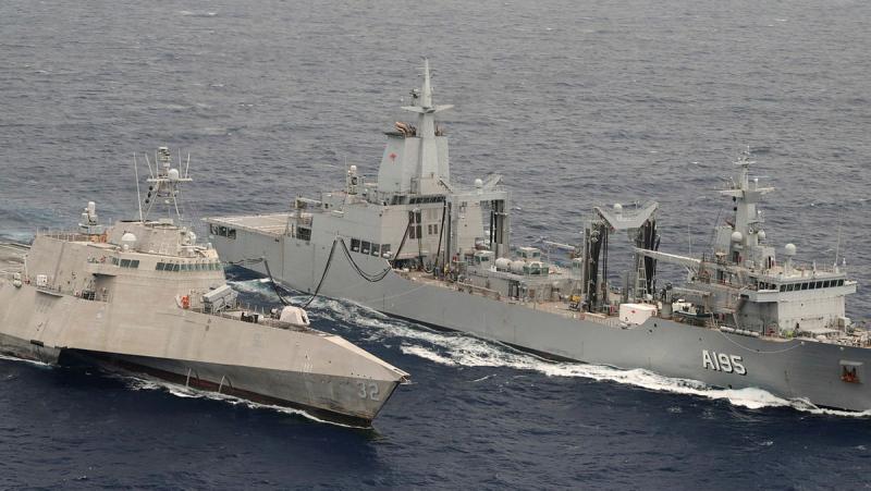 Two ships side by side at sea.