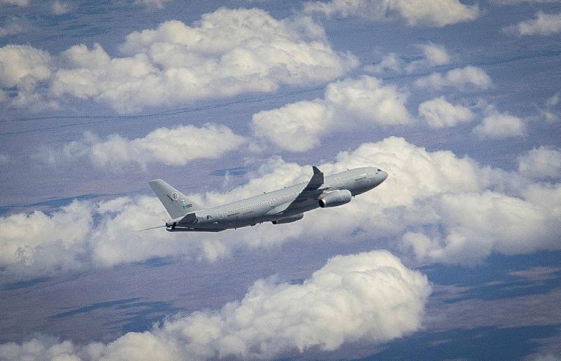 An aircraft in the sky with lots of clouds.