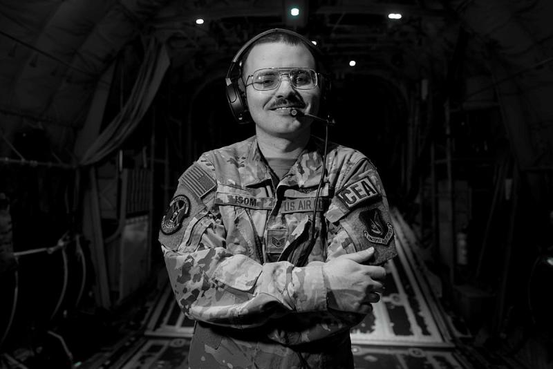 A black and white shot of a military man inside an aircraft.