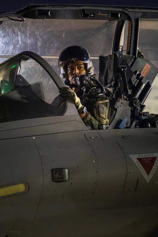 A pilot sits in the cockpit of a jet aircraft.
