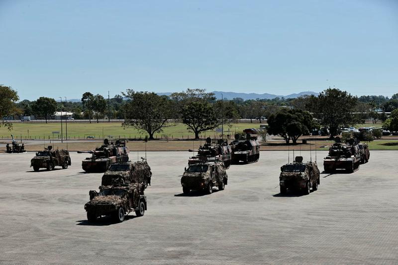 Several different armoured vehicles stand on a parade ground.