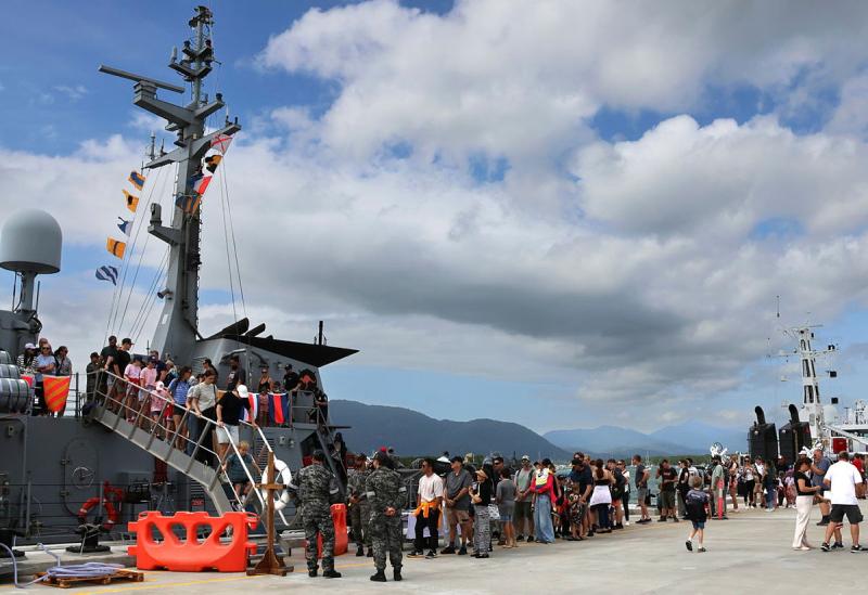 A docked ship attracts a crowd.