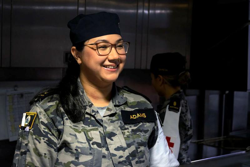 A female Navy member sits for a photo.
