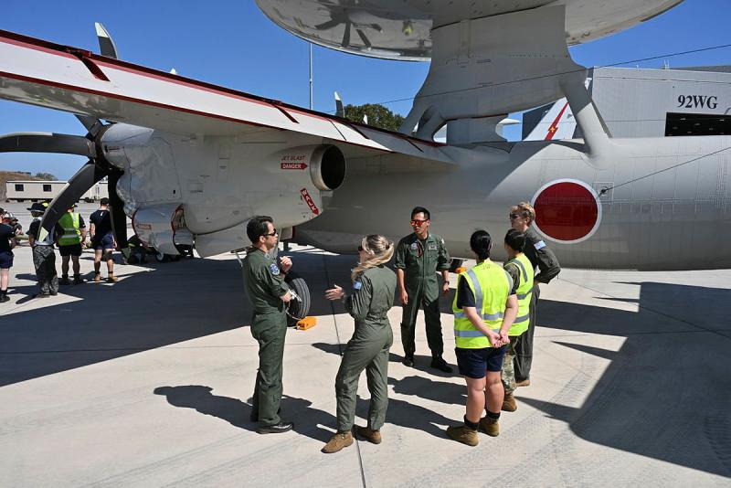A group of aviators stand on the tarmac swapping stories during Exercise Pitch Black 26.