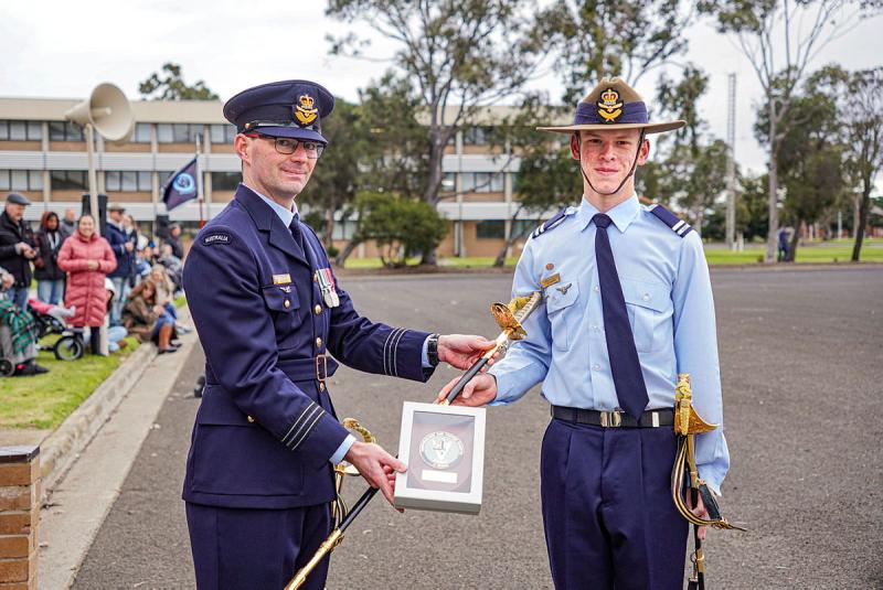 An Air Force leader presents a cadet with an award