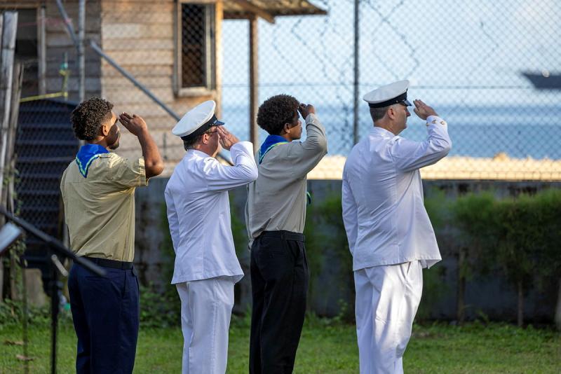 Two military men and two scouts salute.