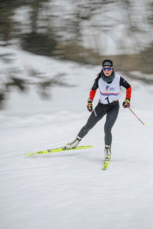 A female skier is shown in action on a snow covered hill.