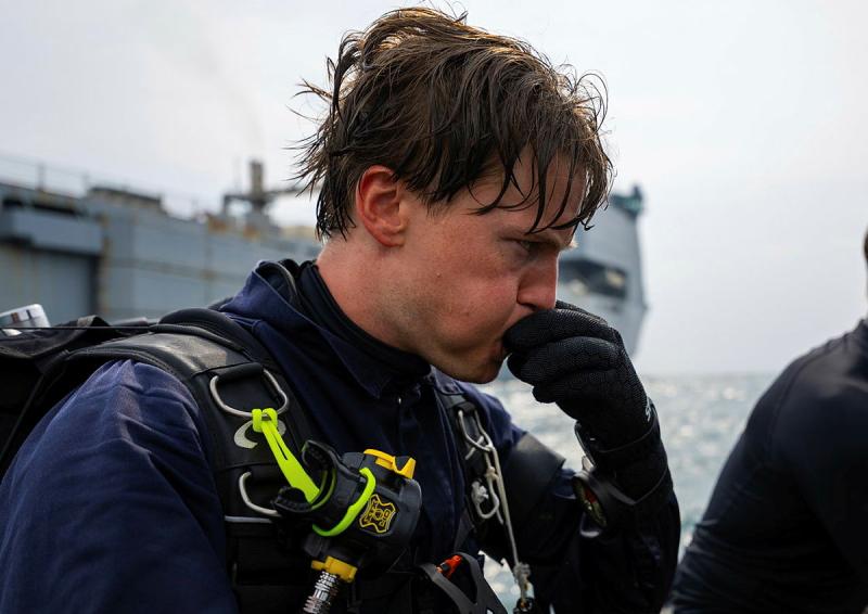 A diver blows into a whistle.