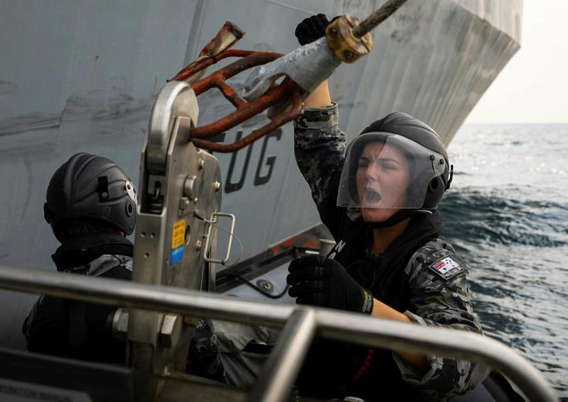 A sailor connects a hook at sea.