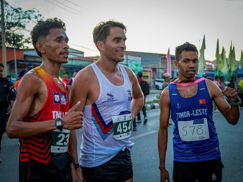Three men in race singlets stand side by side.