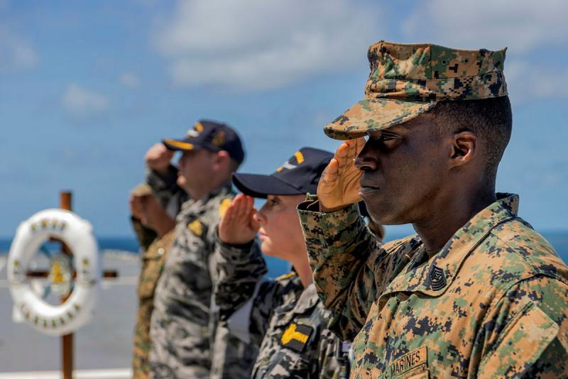 Close up photo of Marine Rotational Force - Darwin, Sergeant Major Damien Blaise and HMAS Canberra Command Warrant Officer Susie Heffernan saluting.