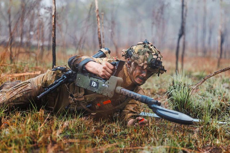 Australian Army soldier lies on the ground in a live training exercise.