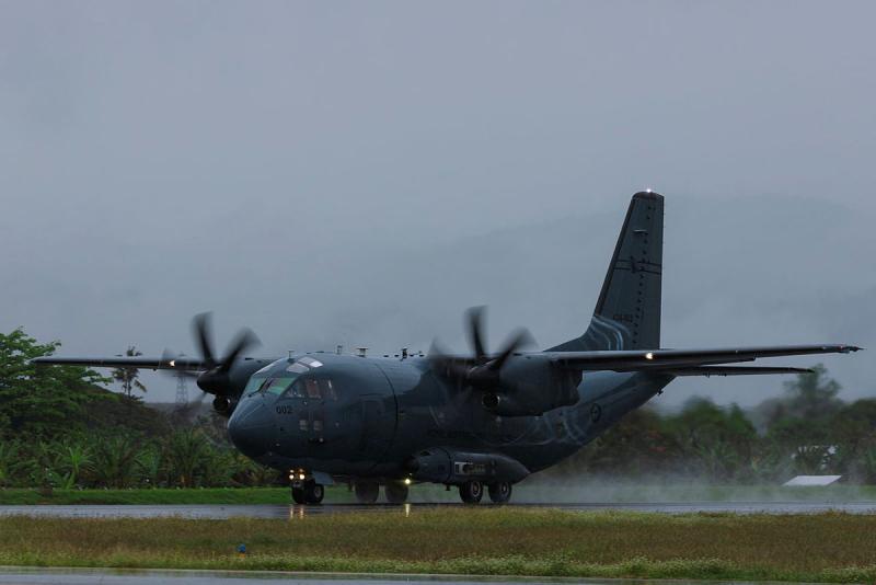 An aircraft on the tarmac, with its propellers spinning.