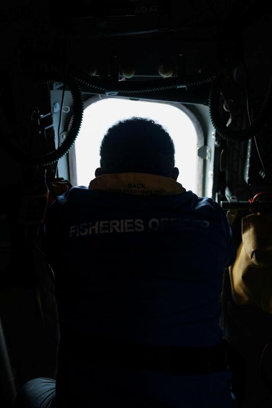 A man looks out the window of an aircraft.