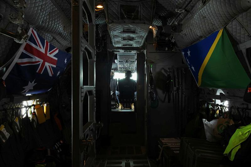 Two flags hung up inside an aircraft with a man visible in the cockpit.