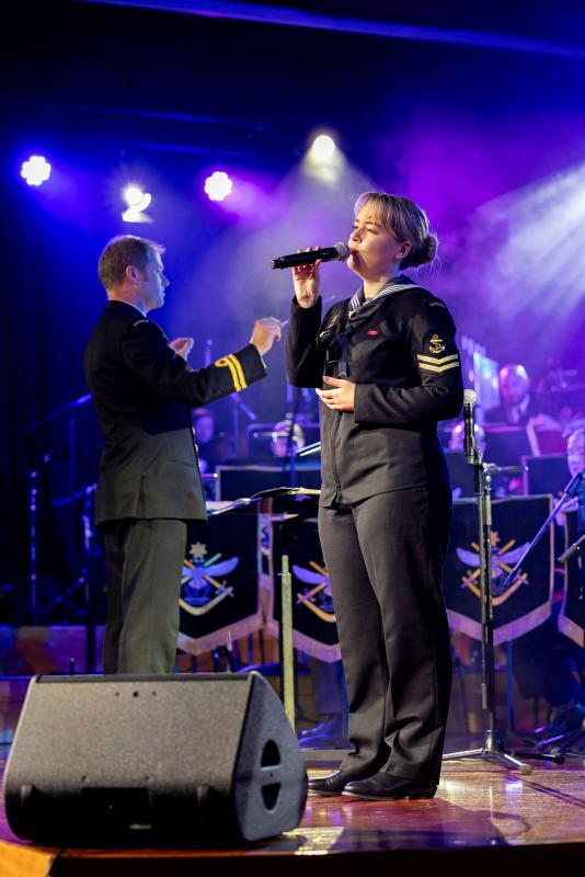 A sailor sings on stage.