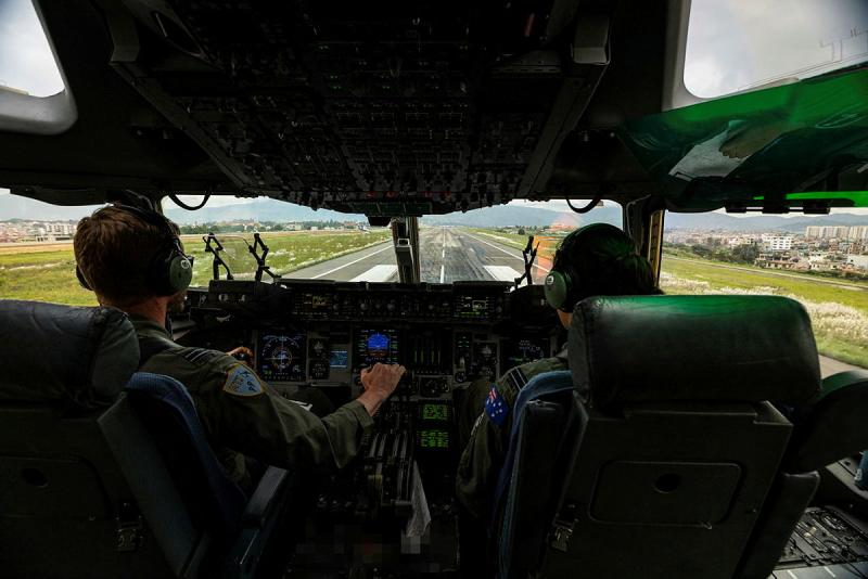Two pilots in the cockpit of an aircraft land on the runway.