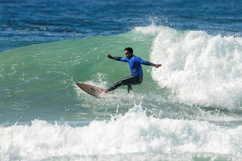 A male surfer rides a swell.