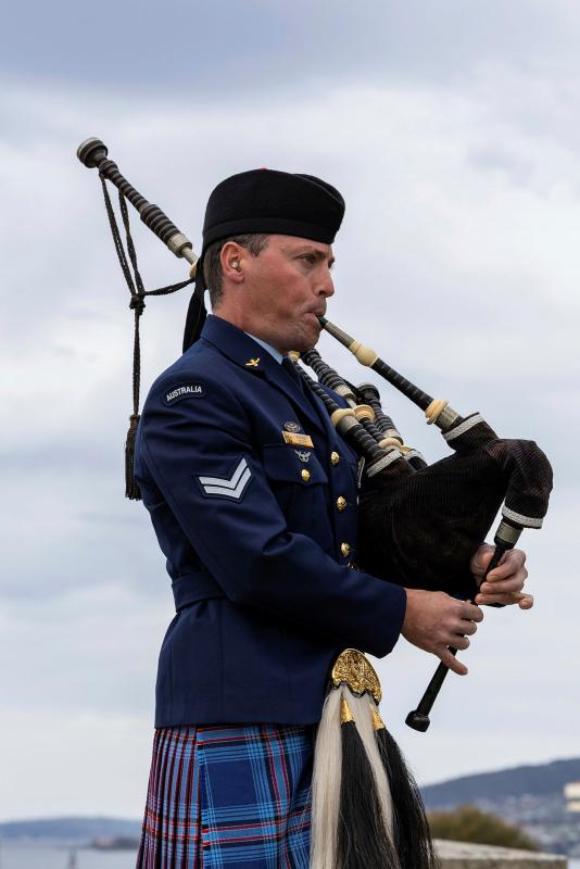 A military man plays the bagpipes.