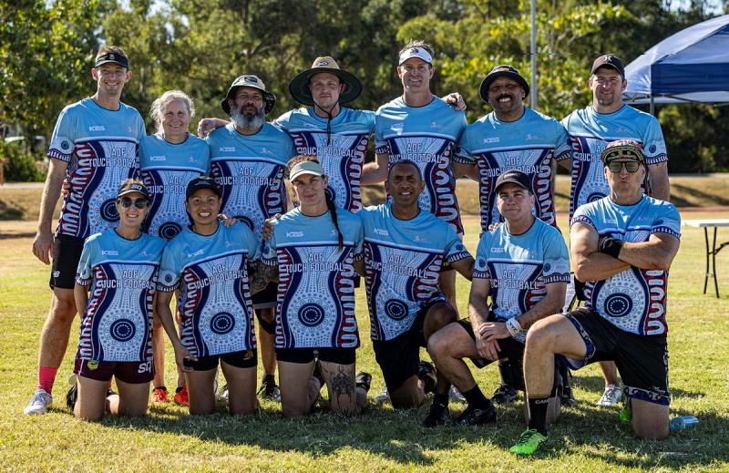 A group of men and women in sports uniform pose for a photo.