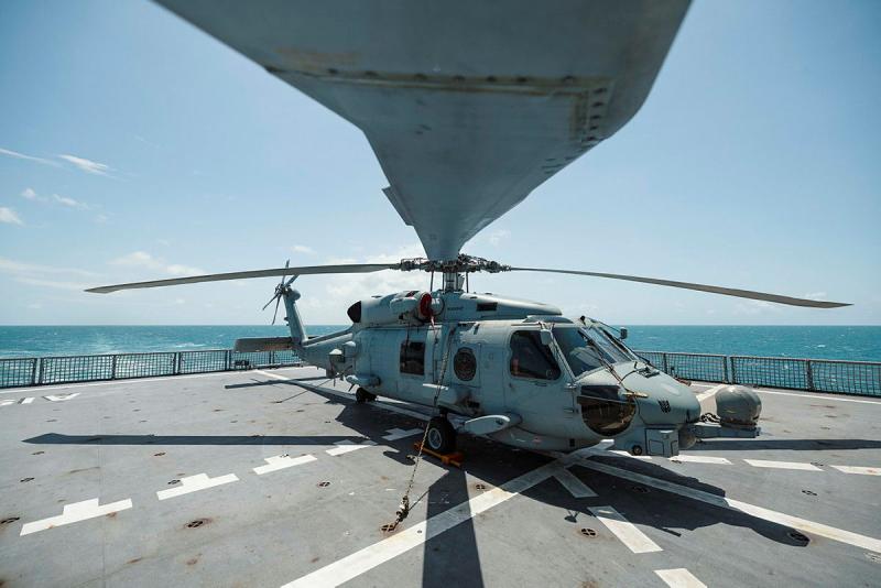 A helicopter on the flight deck of a ship.
