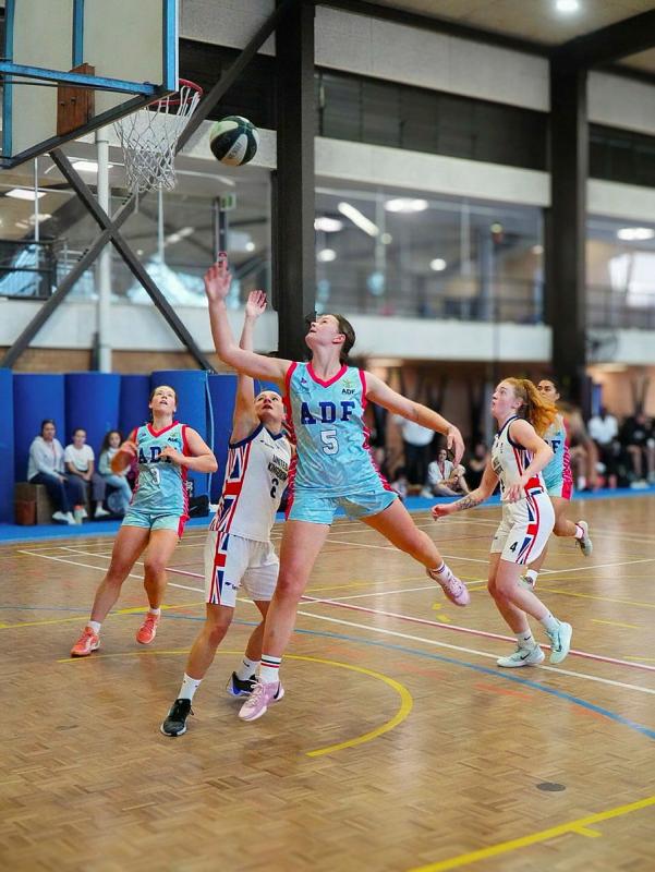 An Australian Defence Force basketballer stretches out and shoots a hoop.
