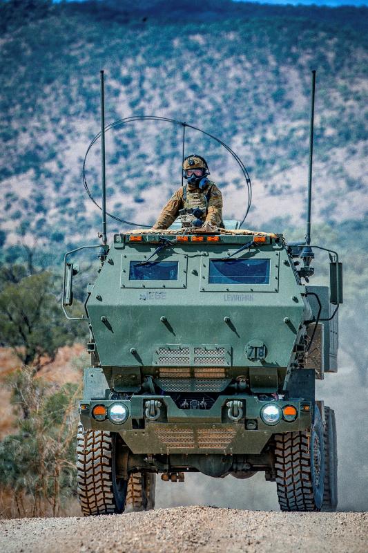 A soldier rides on a tank.