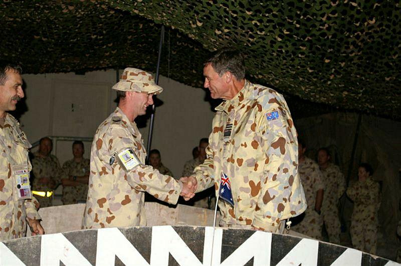 Two military men shake hands.
