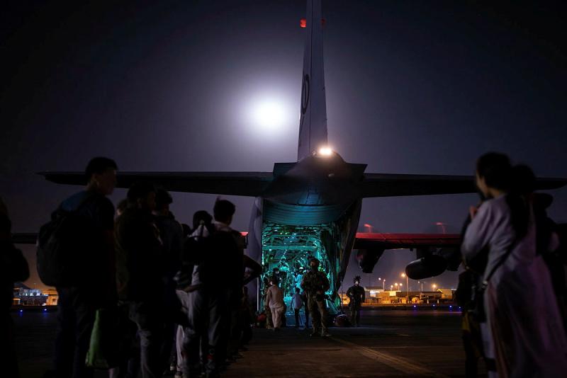 People preparing to board a large aircraft at night.