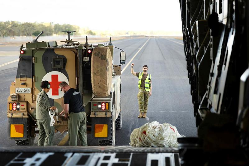 A military medical vehicle is loaded into a larger chamber.