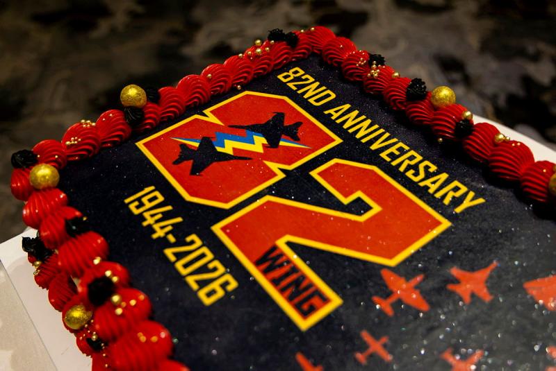 A red and black cake with the words '82WG ANNIVERSARY 82 1944-2026' on the top.