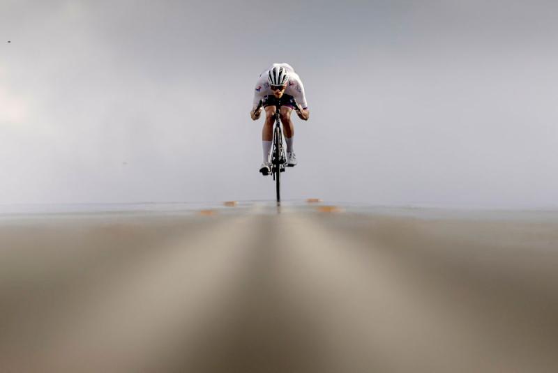 A man hunches over on his bike as he cycles along a road