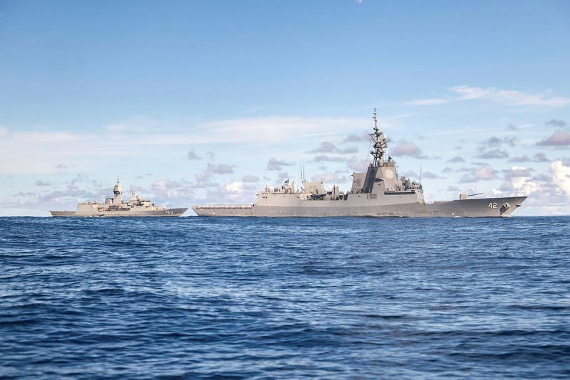 Two ships sail in sync at sea.