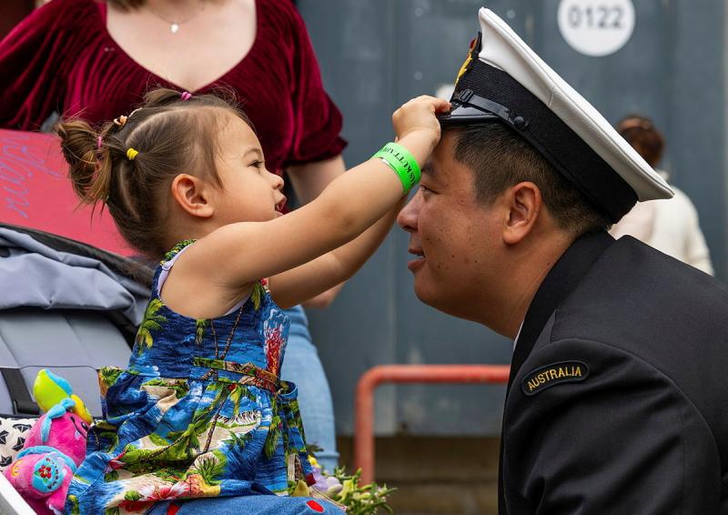 A child plays with a sailor's hat.