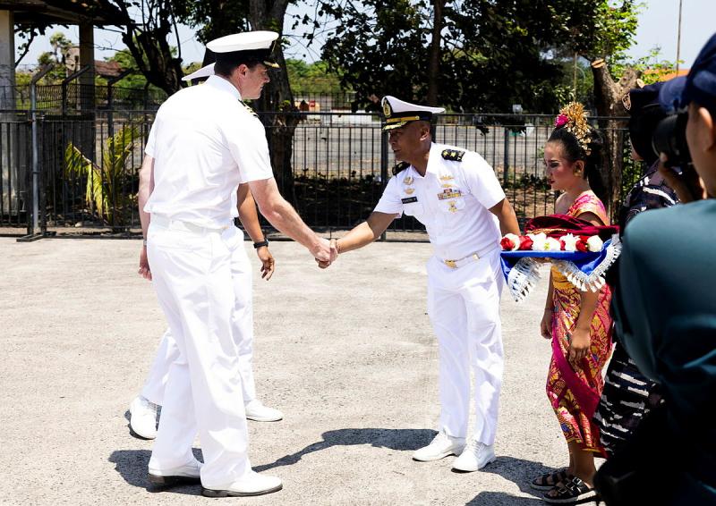 A naval officer shakes the hand of another naval officer.
