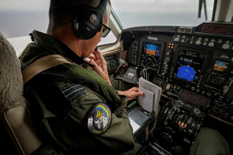 Military pilot examines notepad in the cockpit of a plane