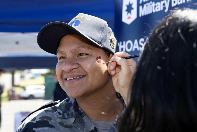 A sailor has his face painted. 