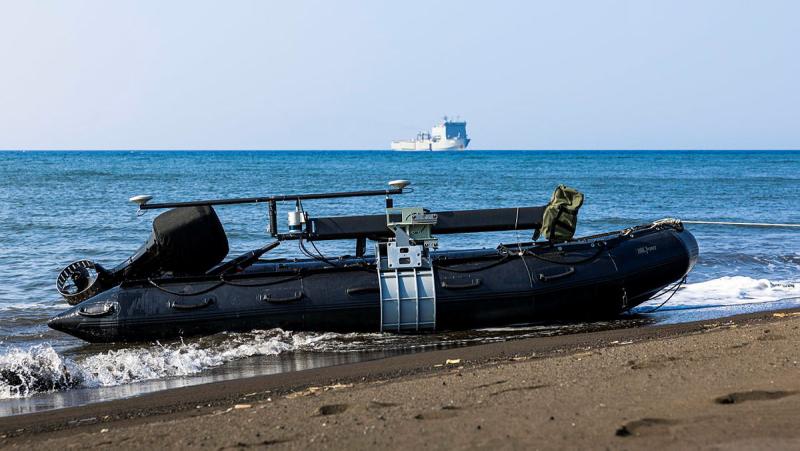 A small inflatable boat pulled ashore on the beach.